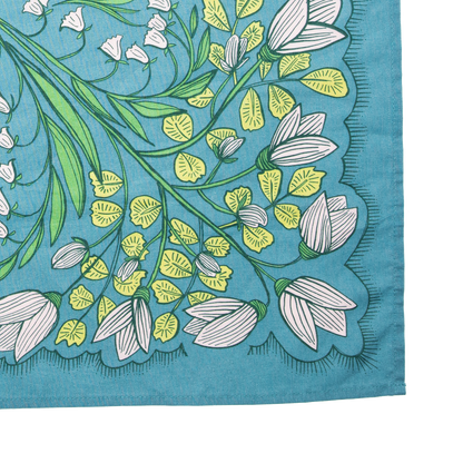 Close-up detail of the Cassie bandana showing the teal cotton fabric, white floral print, green leaves, and stitched edge.