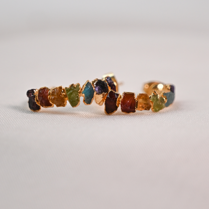 Side view of gold-plated hoop earrings accented with colorful raw natural stones.