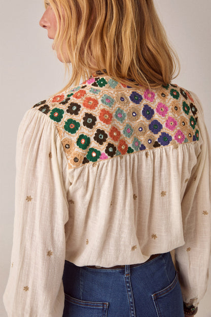 Back view of the Cleo blouse showcasing an intricately embroidered floral yoke in vibrant colors against a soft off-white fabric.