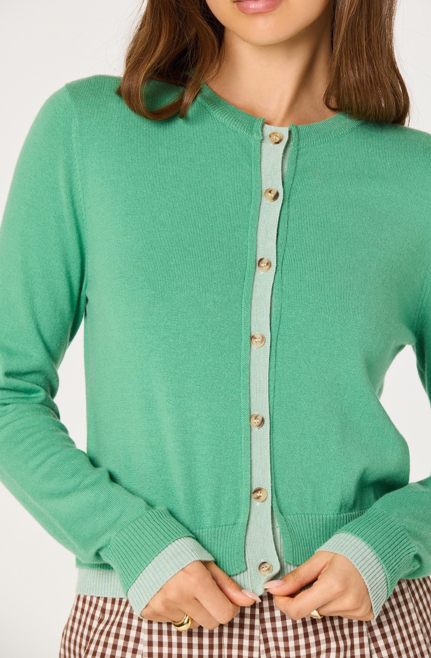 Close-up of the Clovis Color Block Faux Layered Cardigan showing the faux layered contrast placket, buttons, and double ribbed cuffs and hem.