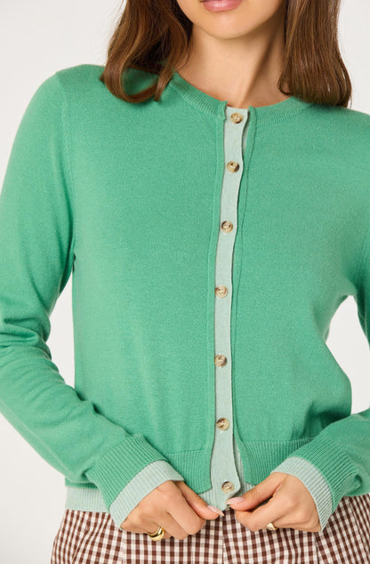 Close-up of the Clovis Color Block Faux Layered Cardigan showing the faux layered contrast placket, buttons, and double ribbed cuffs and hem.