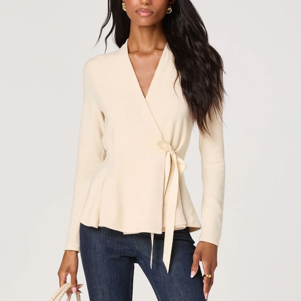 Close-up front view of the Dayna cream knit wrap top with a V-neckline and waist tie closure