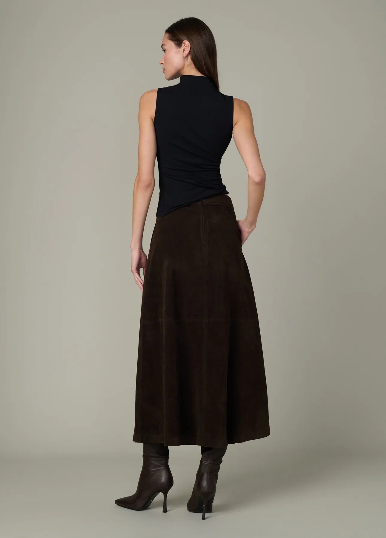 Full-length back view of the black Dove Top paired with a brown midi skirt and dark boots.