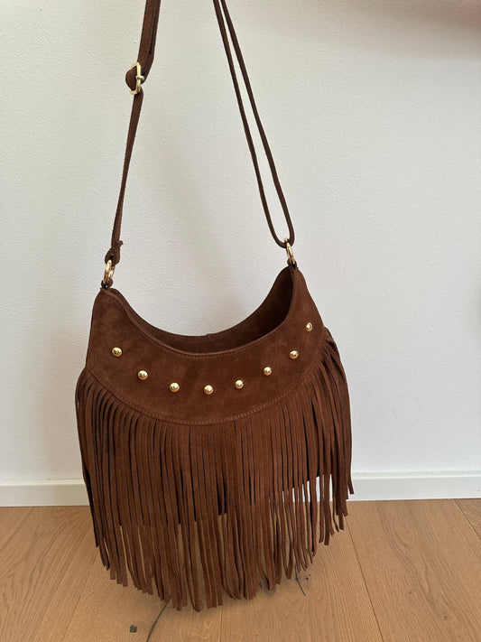 Brown genuine suede crossbody bag with long fringe, gold-tone studs, and an adjustable shoulder strap.