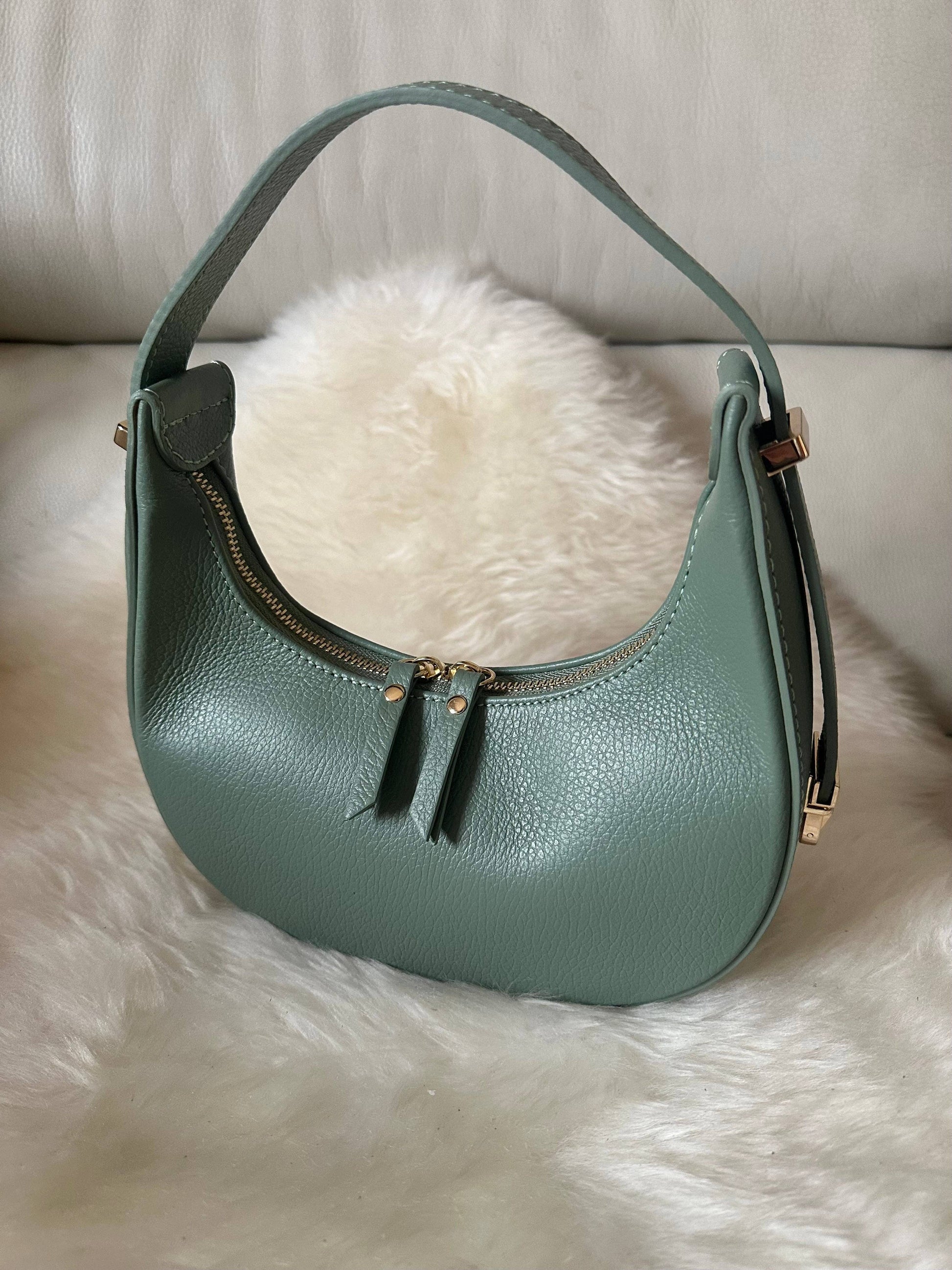 Pistachio genuine dollarino leather mini hobo bag with light gold-tone hardware, top zipper closure, and adjustable shoulder handle.
