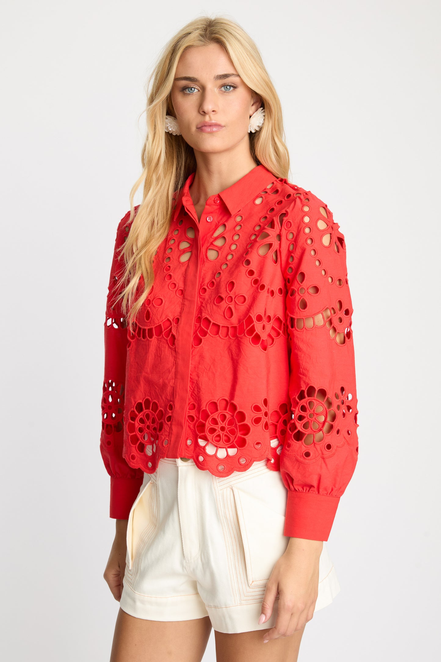 Angled front view of the Emmie Top in Poppy Red Eyelet Lace with embroidered eyelet detailing, scalloped hem, and voluminous long sleeves.