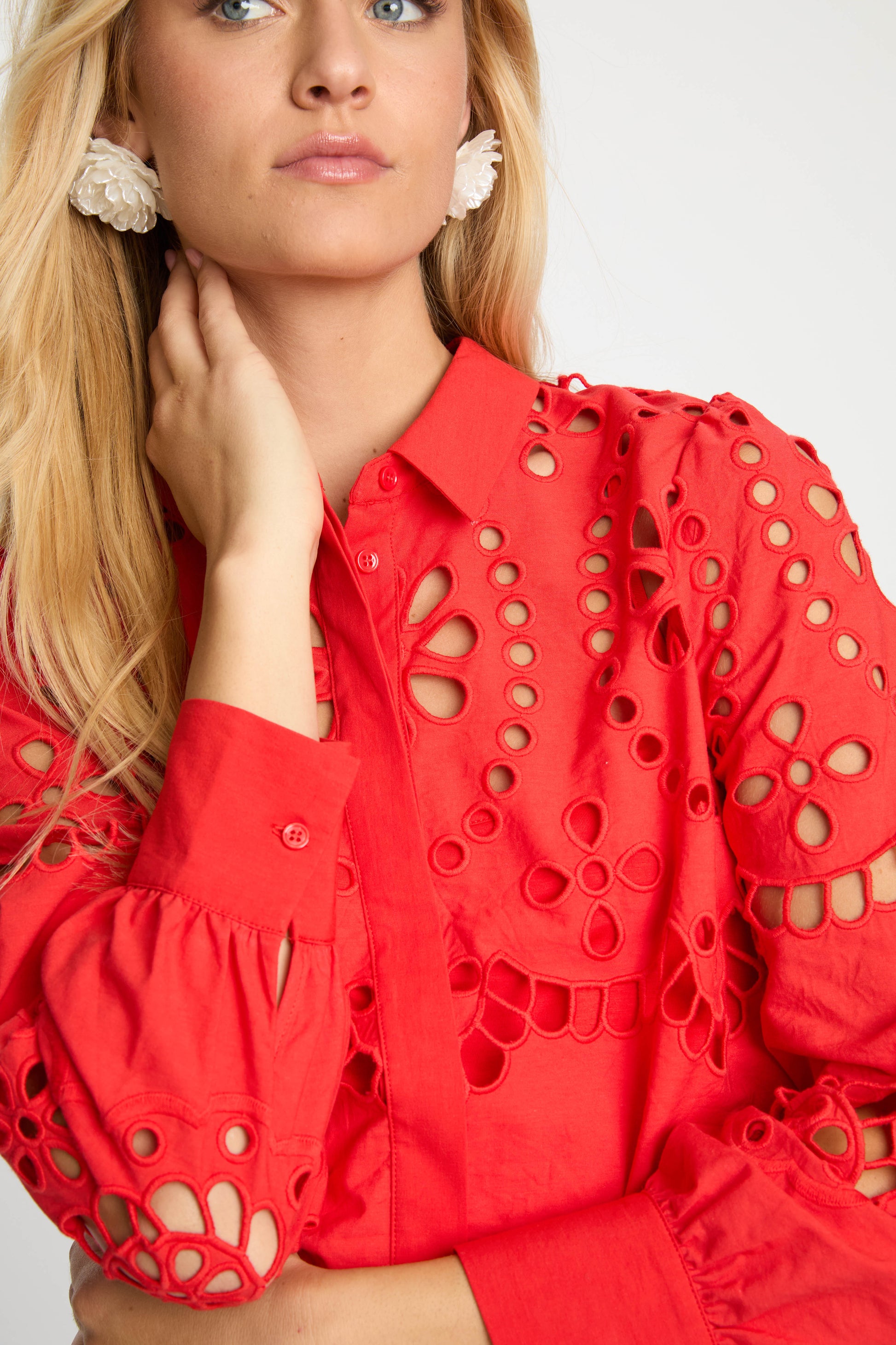Close-up of the Emmie Top in Poppy Red Eyelet Lace showcasing floral eyelet embroidery, puffed sleeves, button-front closure, and scalloped detailing.