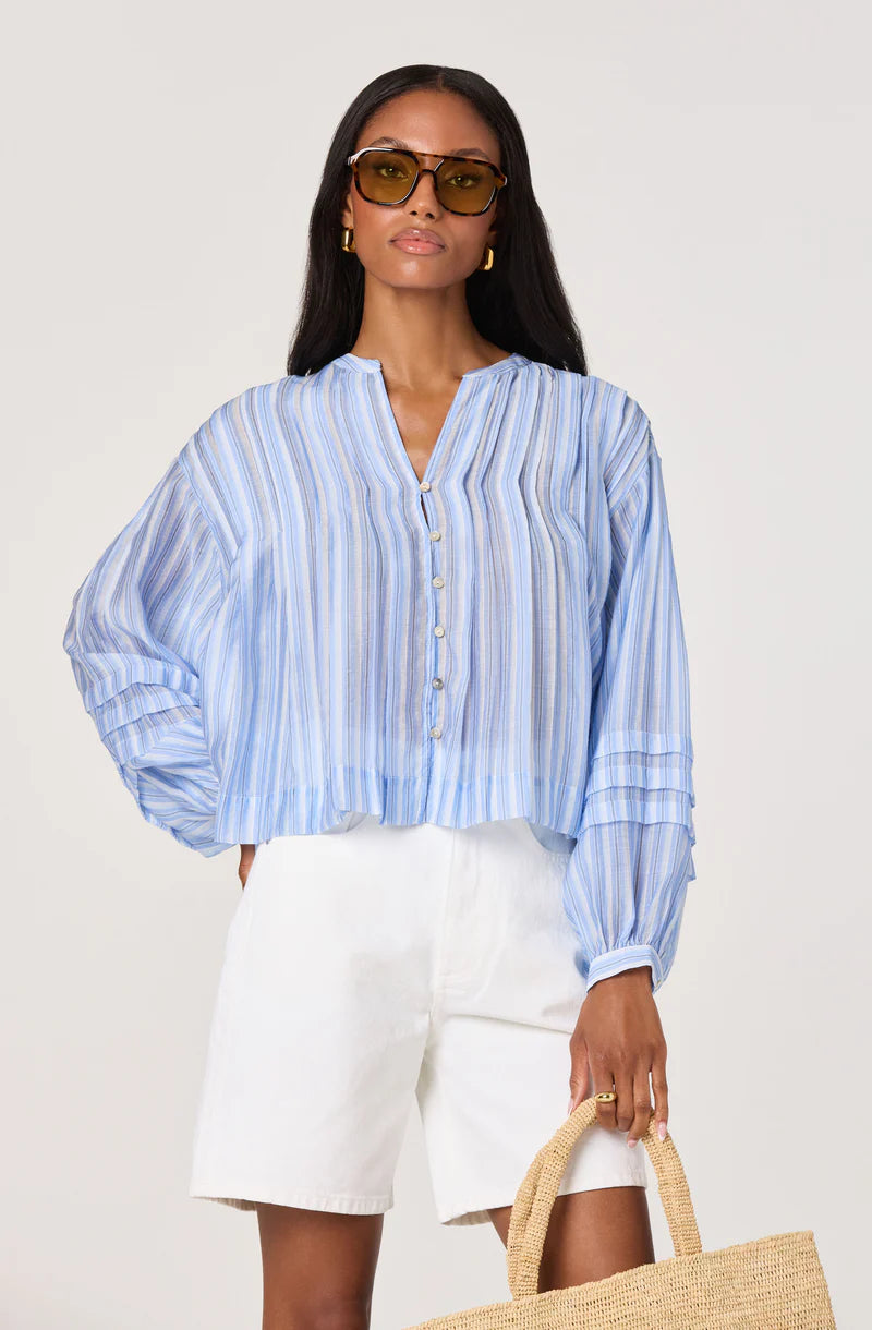 Model wearing the Ericka Top in blue and white stripe with long blouson sleeves and partial button-front detail