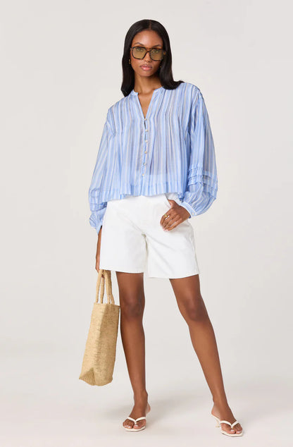 Model wearing the Ericka Top in blue stripe paired with white shorts and neutral sandals