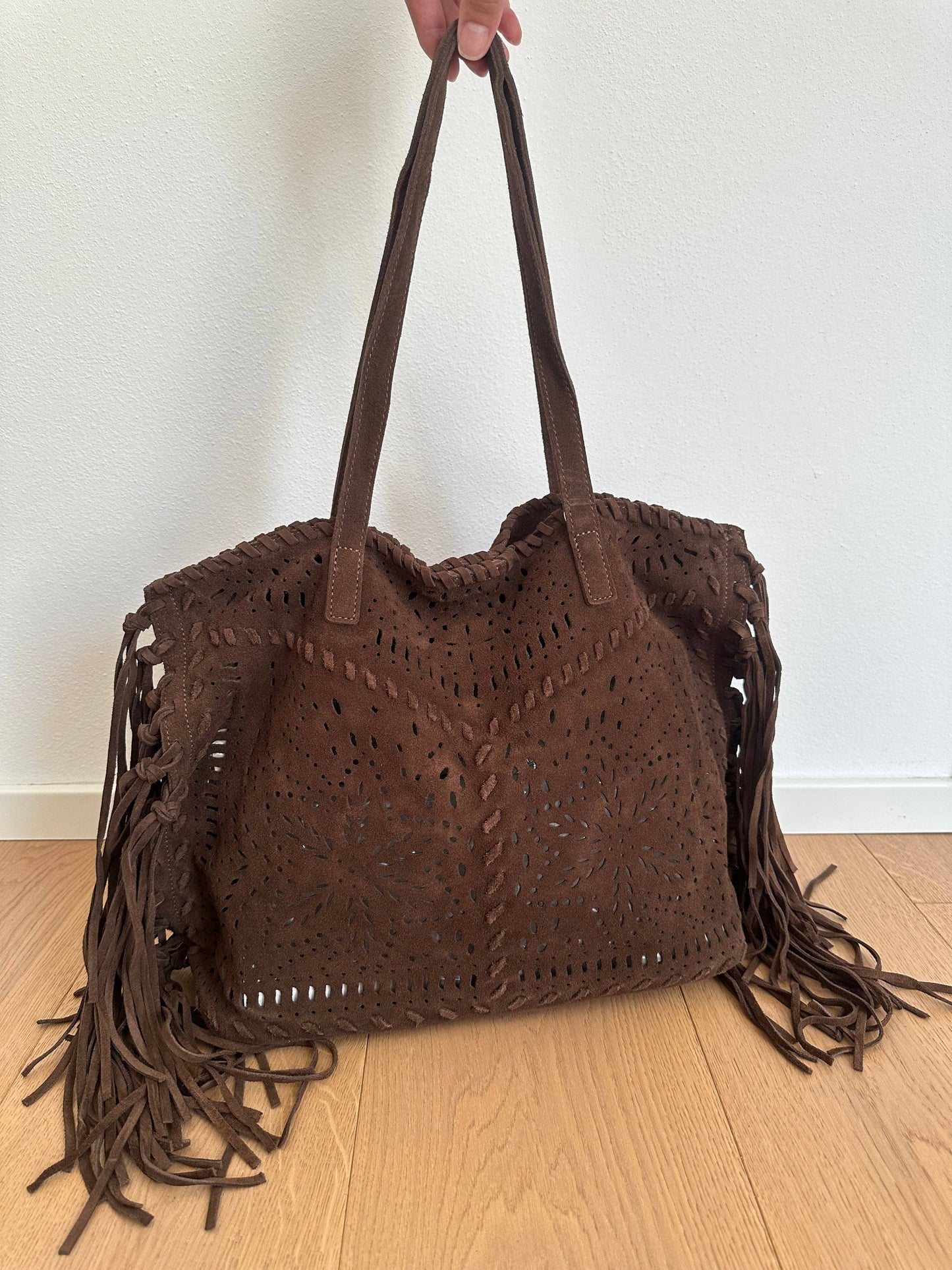 Farah dark brown suede fringe shoulder bag shown at an angle with double handles and decorative perforated detailing.