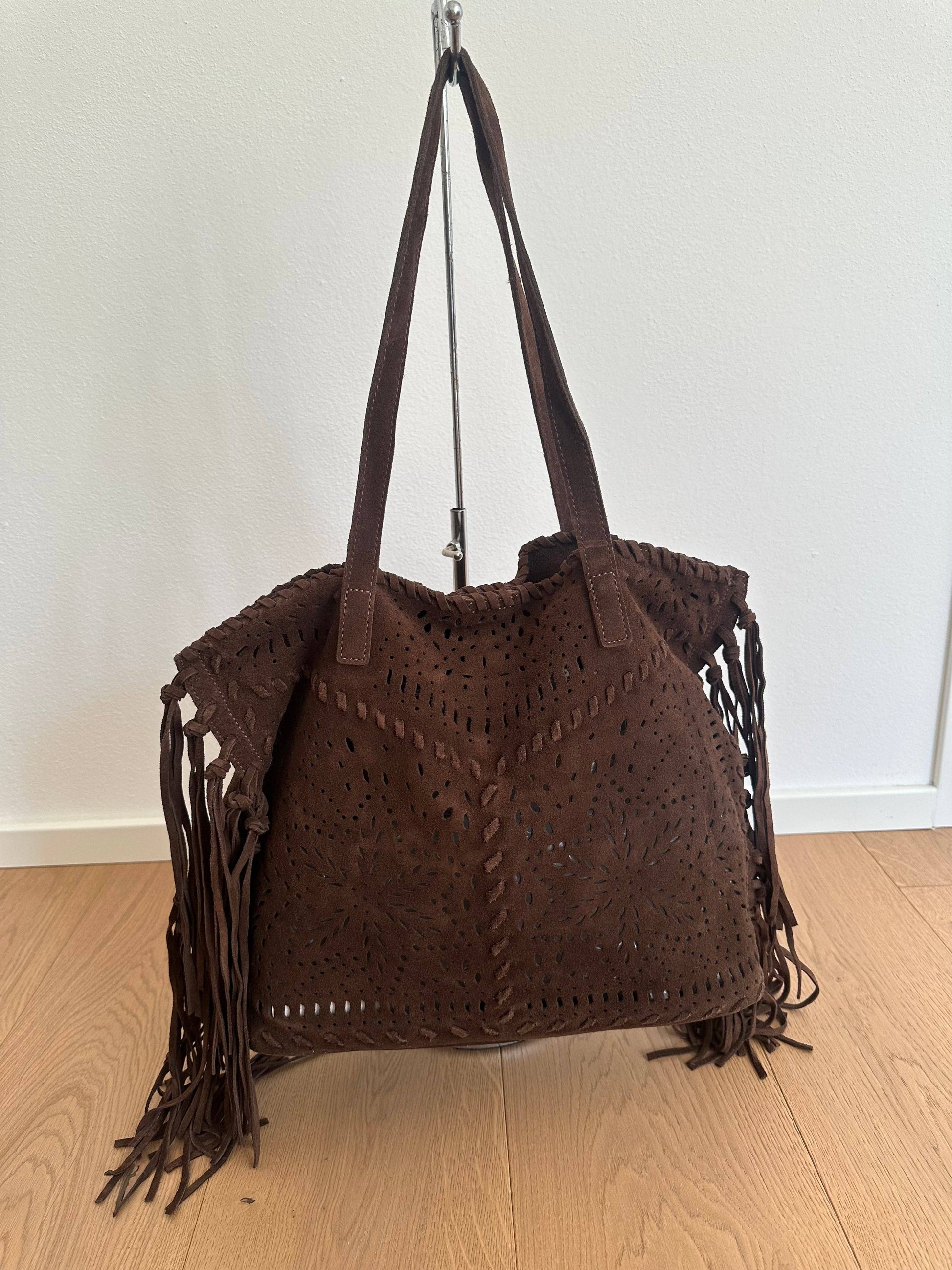 Farah dark brown suede shoulder bag with perforated detailing, long fringe, and double handles, shown from the front.