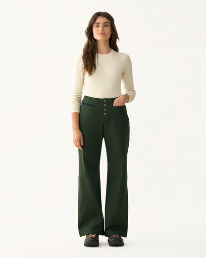 Model wearing the Front Field Pants in deep green with a cream long-sleeve top, shown from the front.