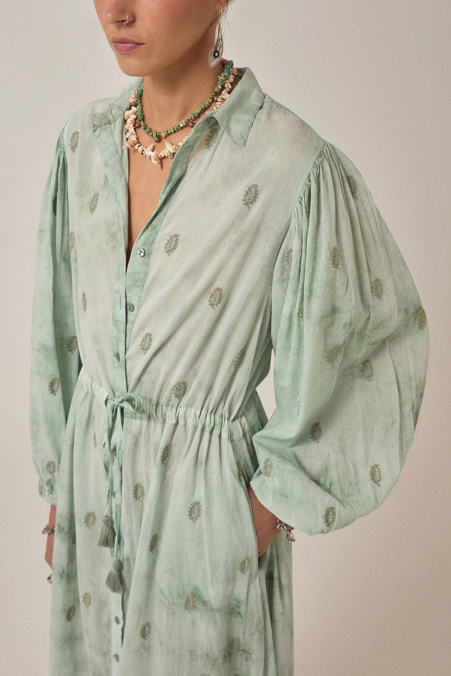 Detailed view of the Freya Dress in Mineral Waves highlighting gathered puff sleeves, tasseled drawstring waist, and delicate paisley print.