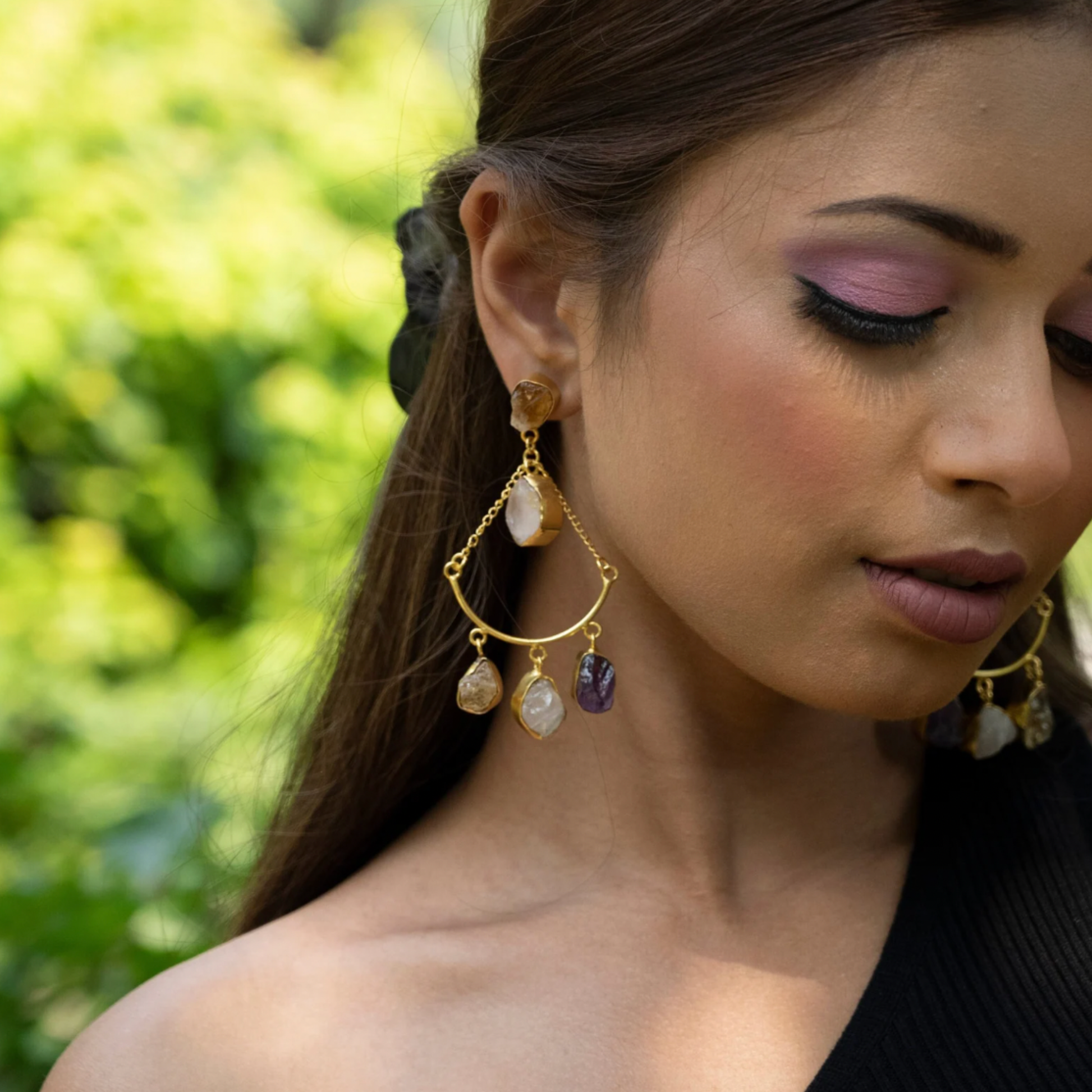 Close-up portrait showing the gold-plated gemstone dangle earring with rose quartz, citrine, and amethyst stones.