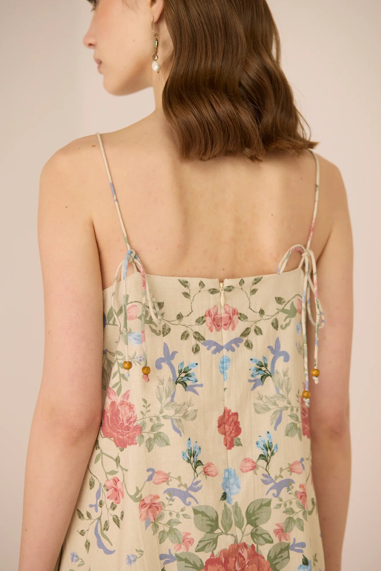 Close-up back detail of the Gili Mini Dress showing the tie-up straps and floral print.