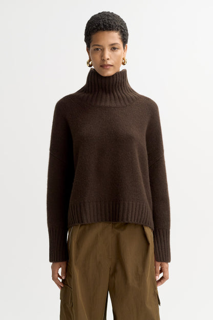 Model wearing the Girlfriend Turtleneck in mocha cashmere with olive trousers, shown from the front.