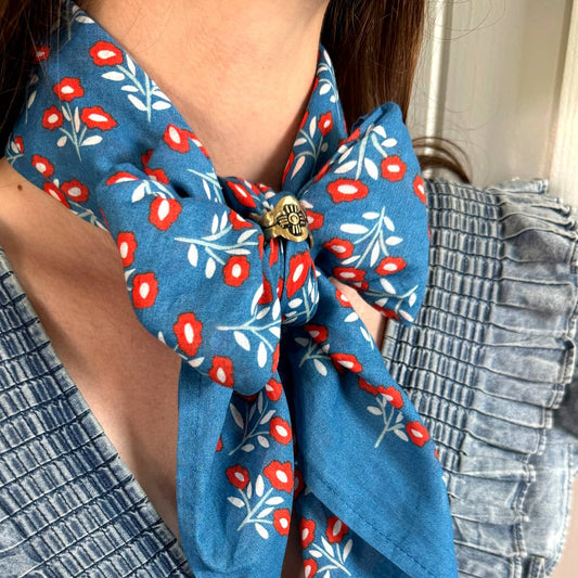 Gladys Brass Bandana Slide Ring styled on a blue floral bandana worn around the neck with a denim top.