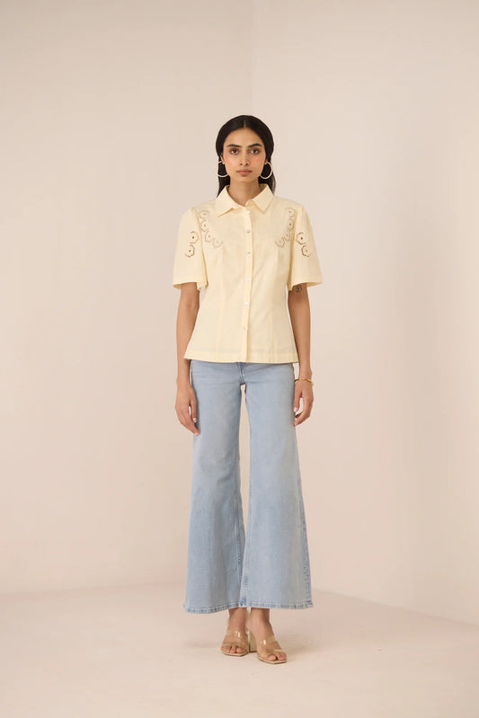 Hartley Shirt in cream cotton poplin with botanical embroidery, shown from the front with light blue jeans.