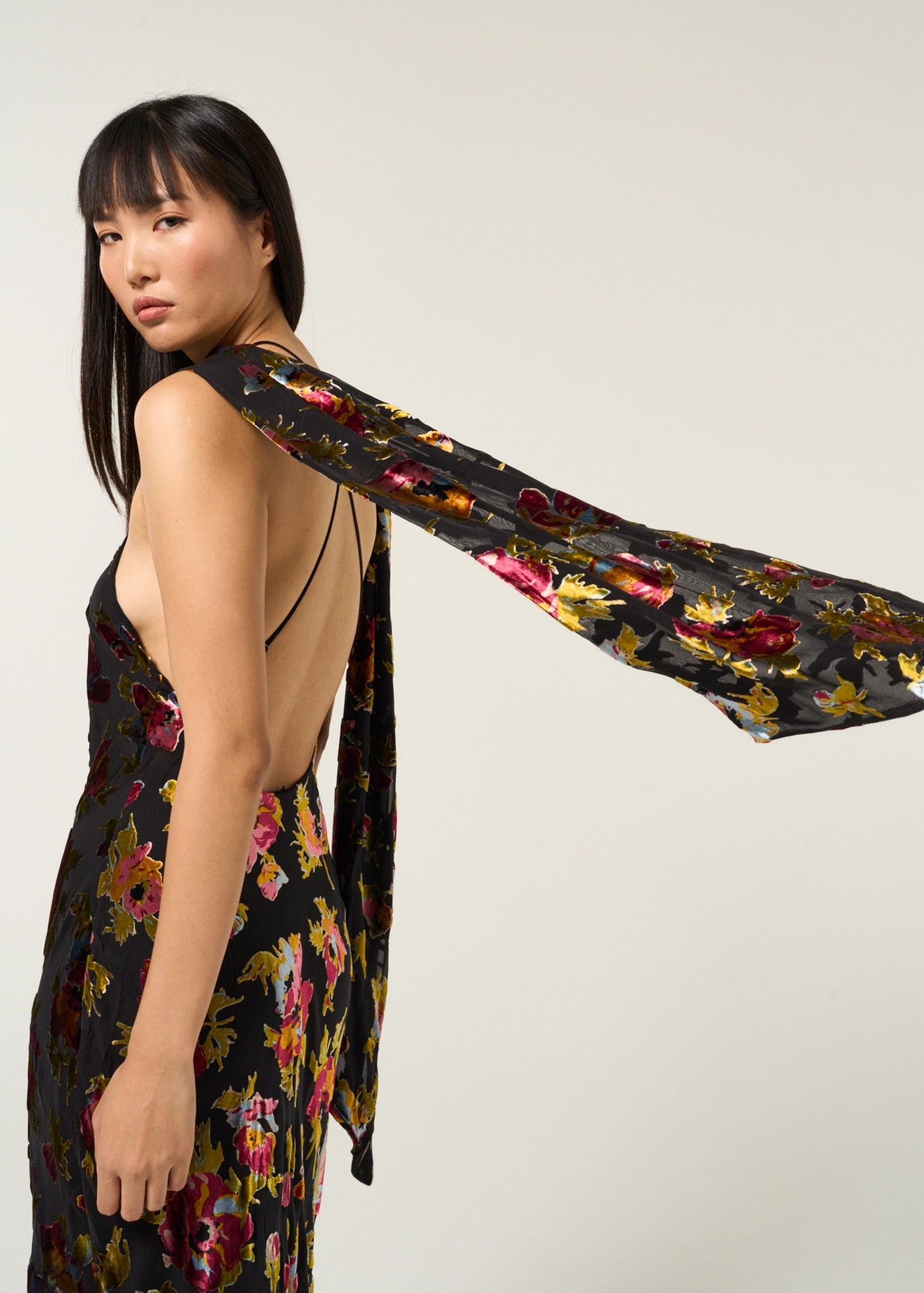 Close-up side view of the Hayley Dress in Countryside Devoré Black highlighting the flowing scarf extension and metallic floral devoré texture.