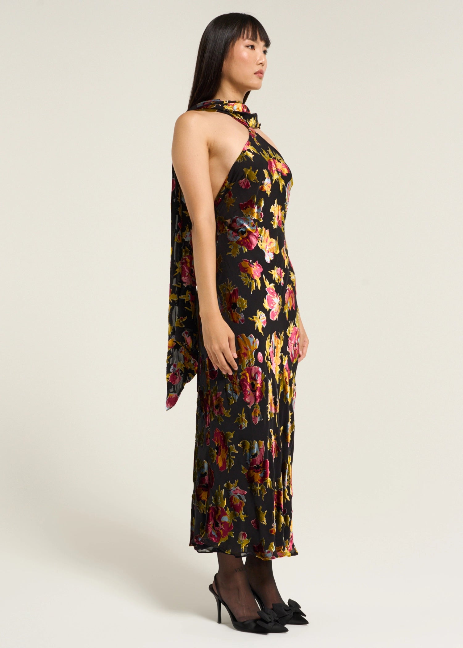 Side profile of the Hayley Dress in Countryside Devoré Black showcasing the halter neckline, floral metallic pattern, and elegant draped scarf detail.