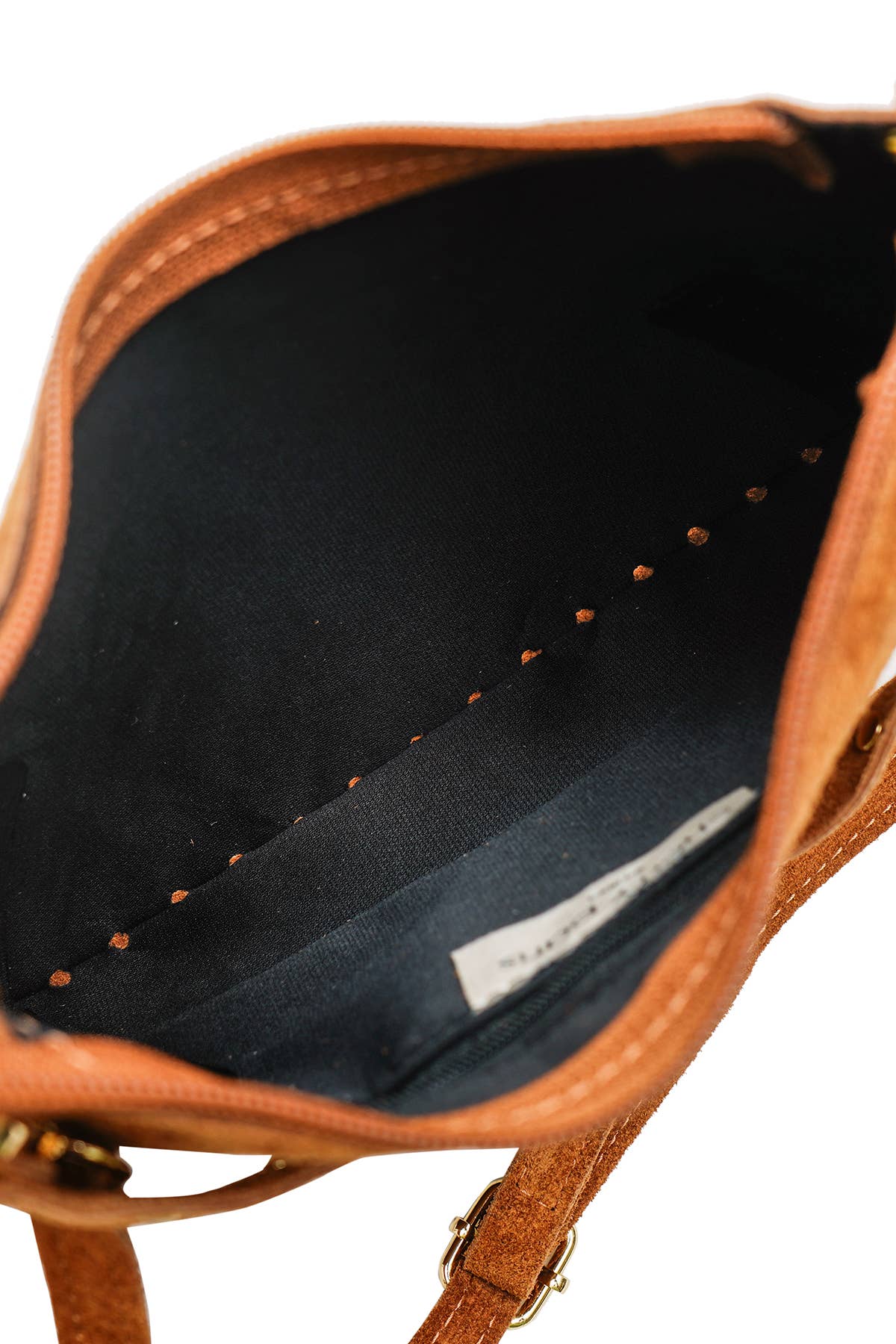 Interior view of the Joëlle camel suede bag showing its dark lining and inner zip compartment.