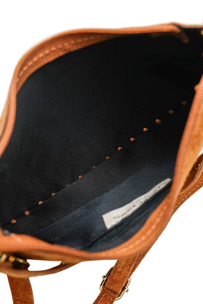 Interior view of the Joëlle camel suede bag showing its dark lining and inner zip compartment.