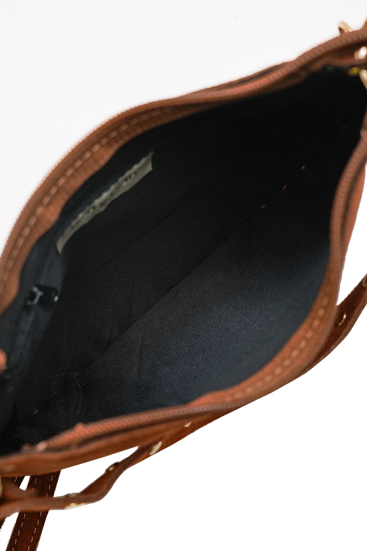 Interior view of the Joelle Suede Bag showing the main zip opening and dark fabric lining.