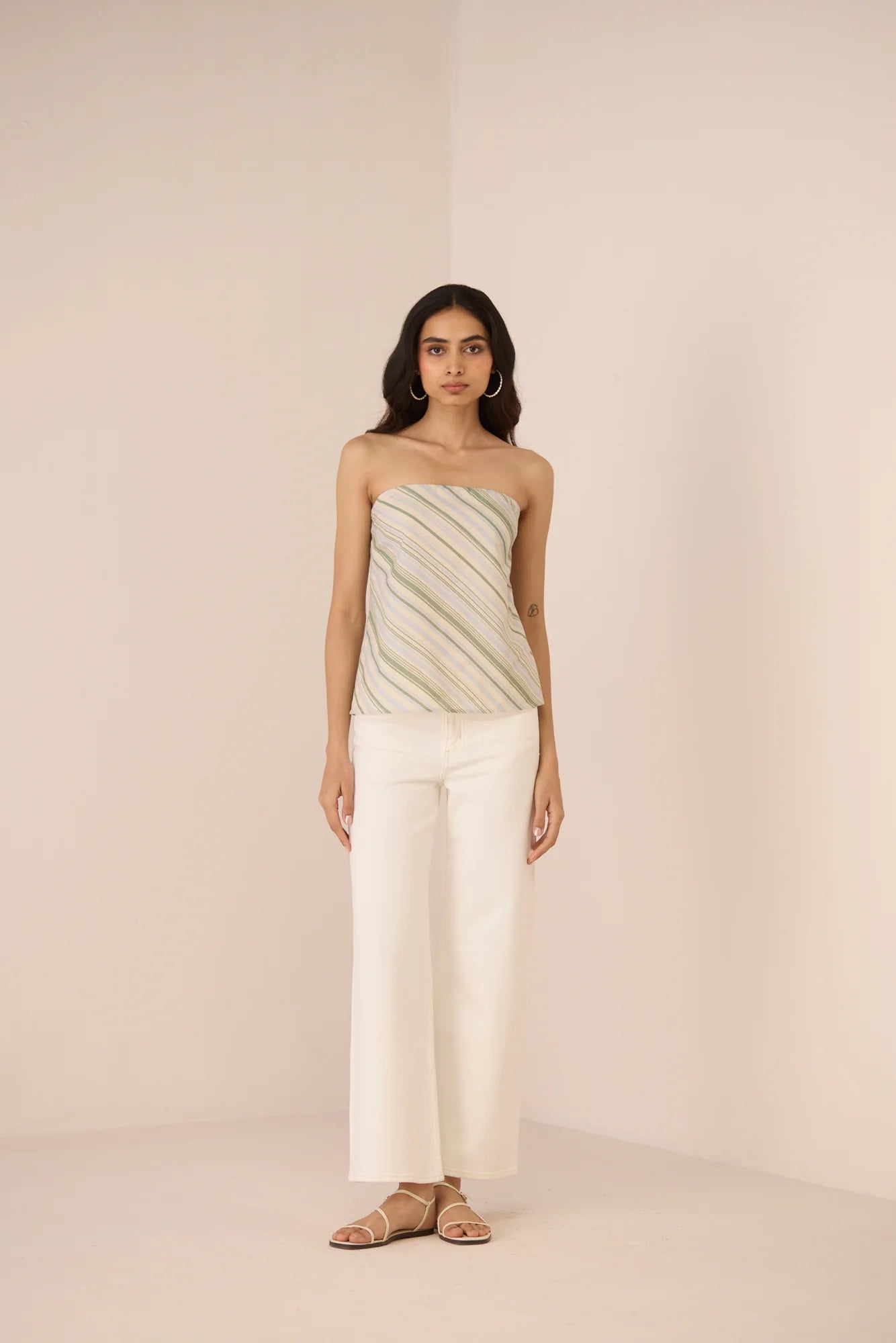 Full outfit front view of the Josie Diagonal Stripe Tube Top styled with white pants and neutral sandals.