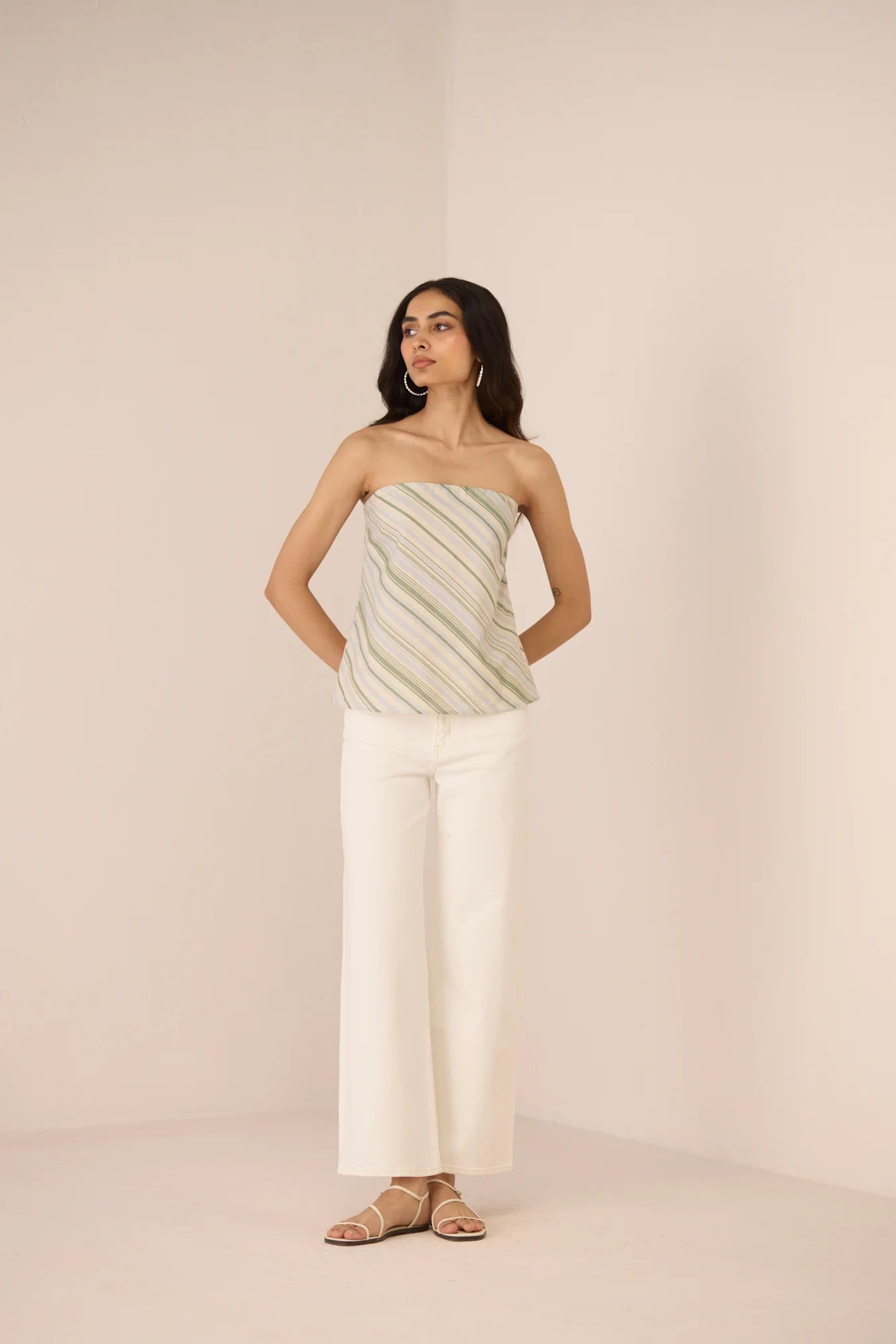 Model wearing the Josie Diagonal Stripe Tube Top with white pants, showing the cream and green diagonal stripe print.