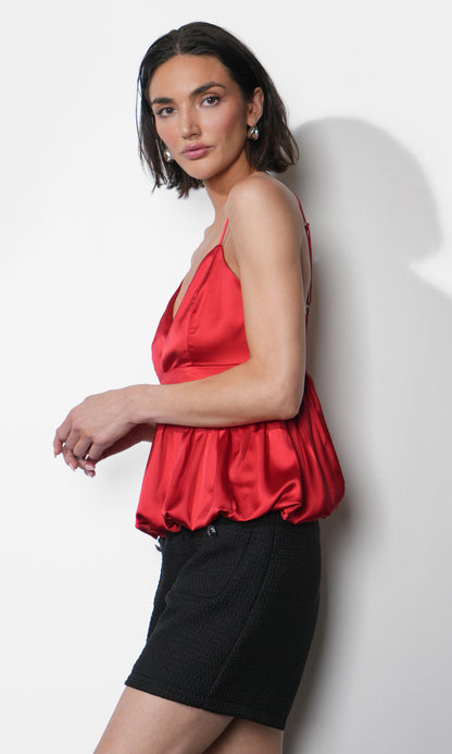 Side profile of the Julia Bubble Hem Babydoll Cami in vibrant red satin-like fabric showing the gathered bubble hem and flattering babydoll silhouette.