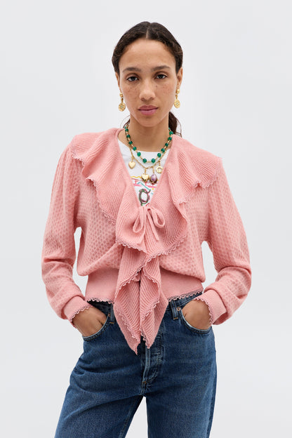 Model wearing the Kianna Cardigan in blush featuring a tie-front closure, cascading ruffles, textured knit fabric, and long sleeves.