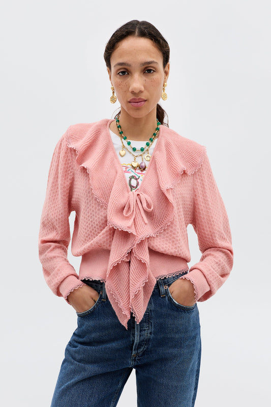 Model wearing the Kianna Cardigan in blush featuring a tie-front closure, cascading ruffles, textured knit fabric, and long sleeves.
