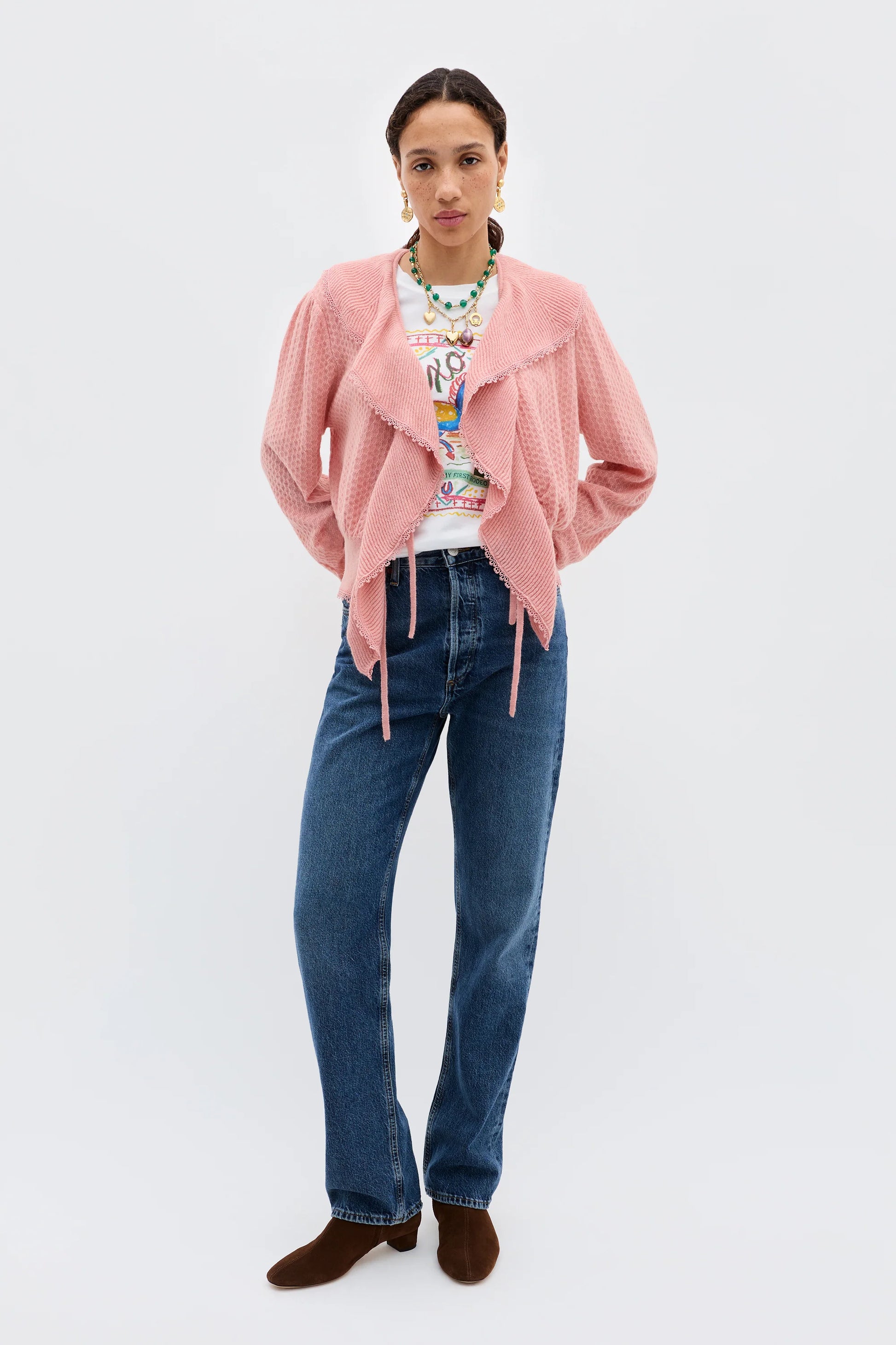 Full-length view of the Kianna blush cardigan styled with denim jeans, showcasing the ruffled deep V-neckline and lightweight textured fabric.