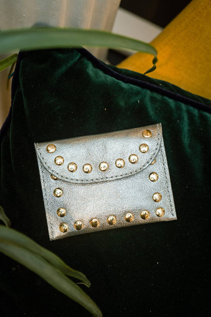 LEINA pewter metallic studded wallet styled inside a dark green handbag.