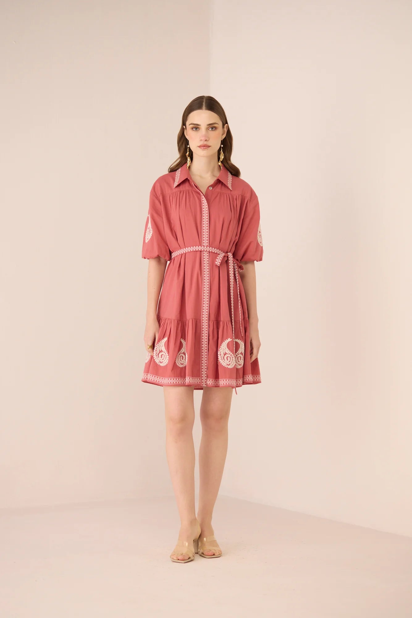 Model wearing the Lizzie Mini Dress in dusty rose with cream paisley embroidery, matching belt, and short sleeves.