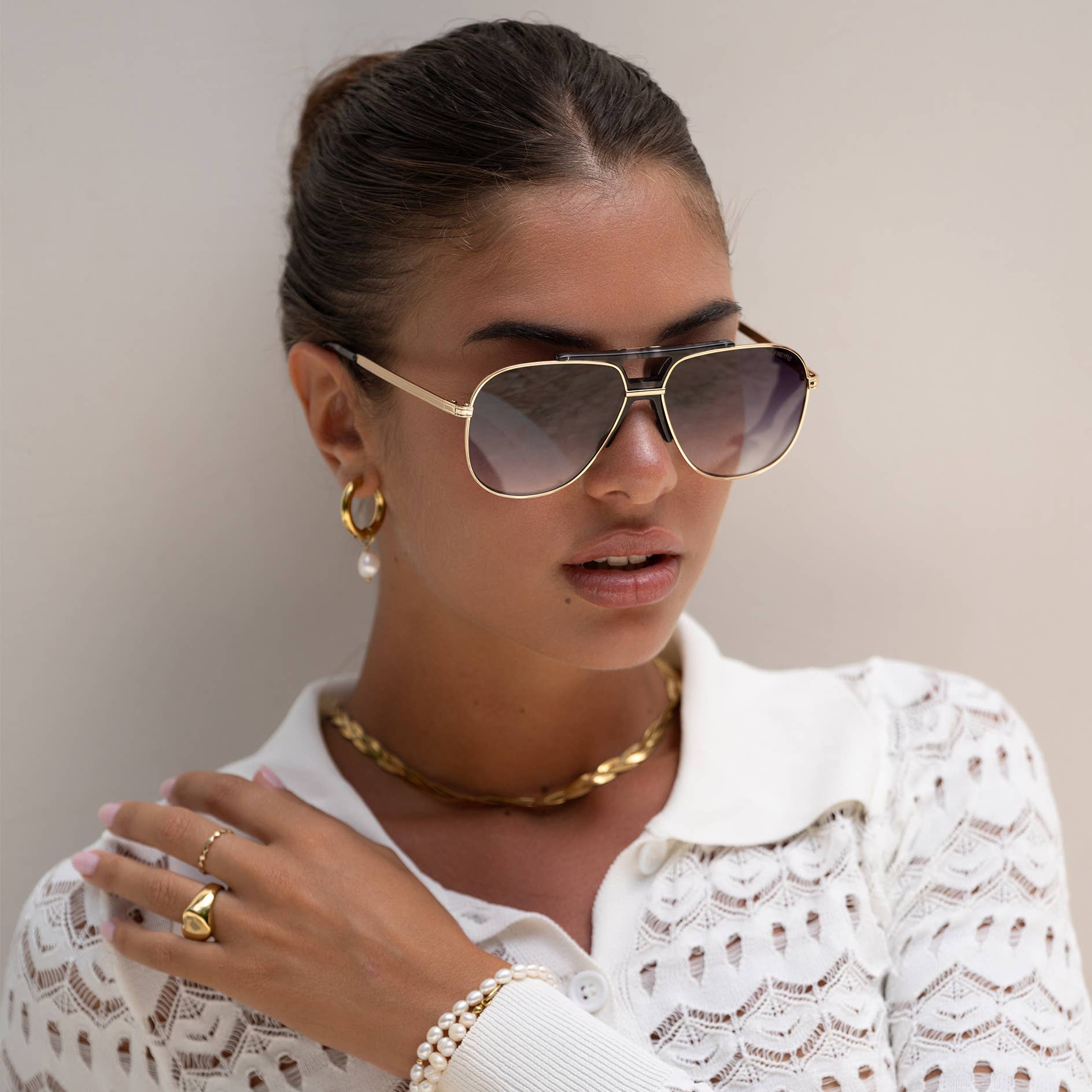 Model wearing Logan acetate aviator unisex sunglasses with a light gold frame and gray lenses.
