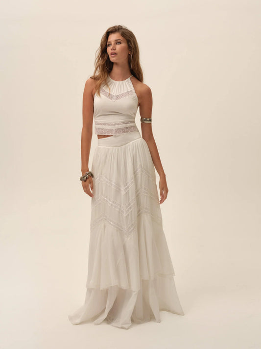 Model wearing the Lou Scarf Top in ivory with a halter neckline, embroidered detailing, and matching flowing maxi skirt front view.
