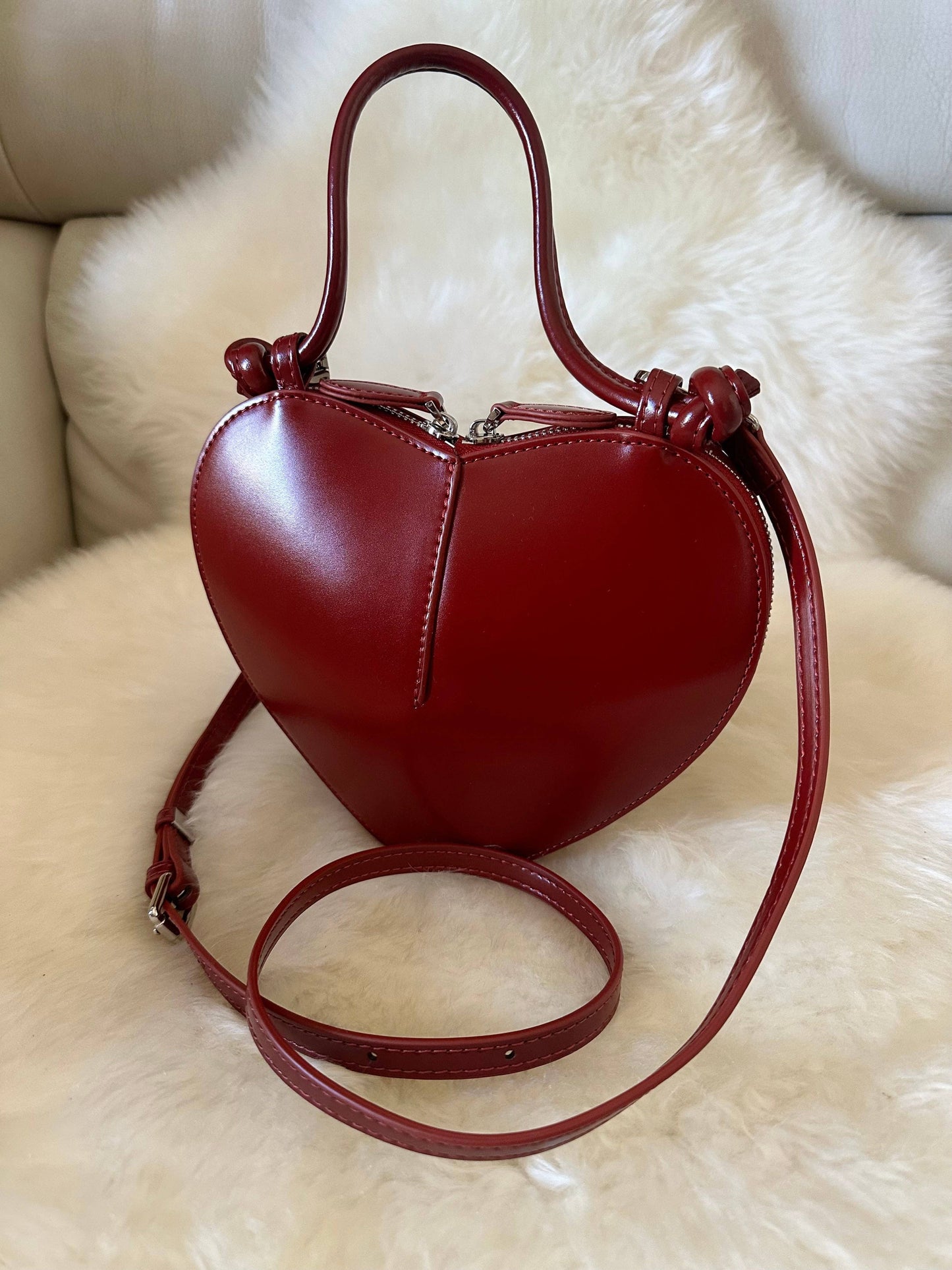 Front view of the Love Heart-Shaped Genuine Leather Handbag in Burgundy featuring a structured heart-shaped silhouette, top handle, and detachable shoulder strap.
