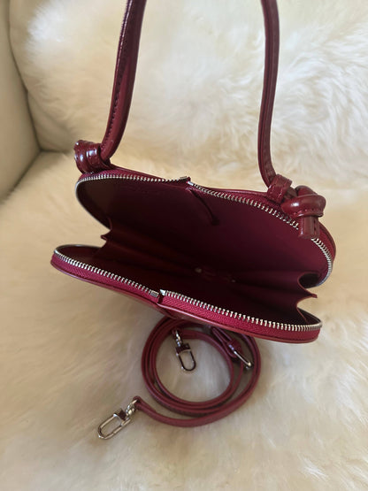Open view of the Love Heart-Shaped Genuine Leather Handbag in Burgundy showing the leather-lined interior, dual zip closure, and detachable adjustable shoulder strap.