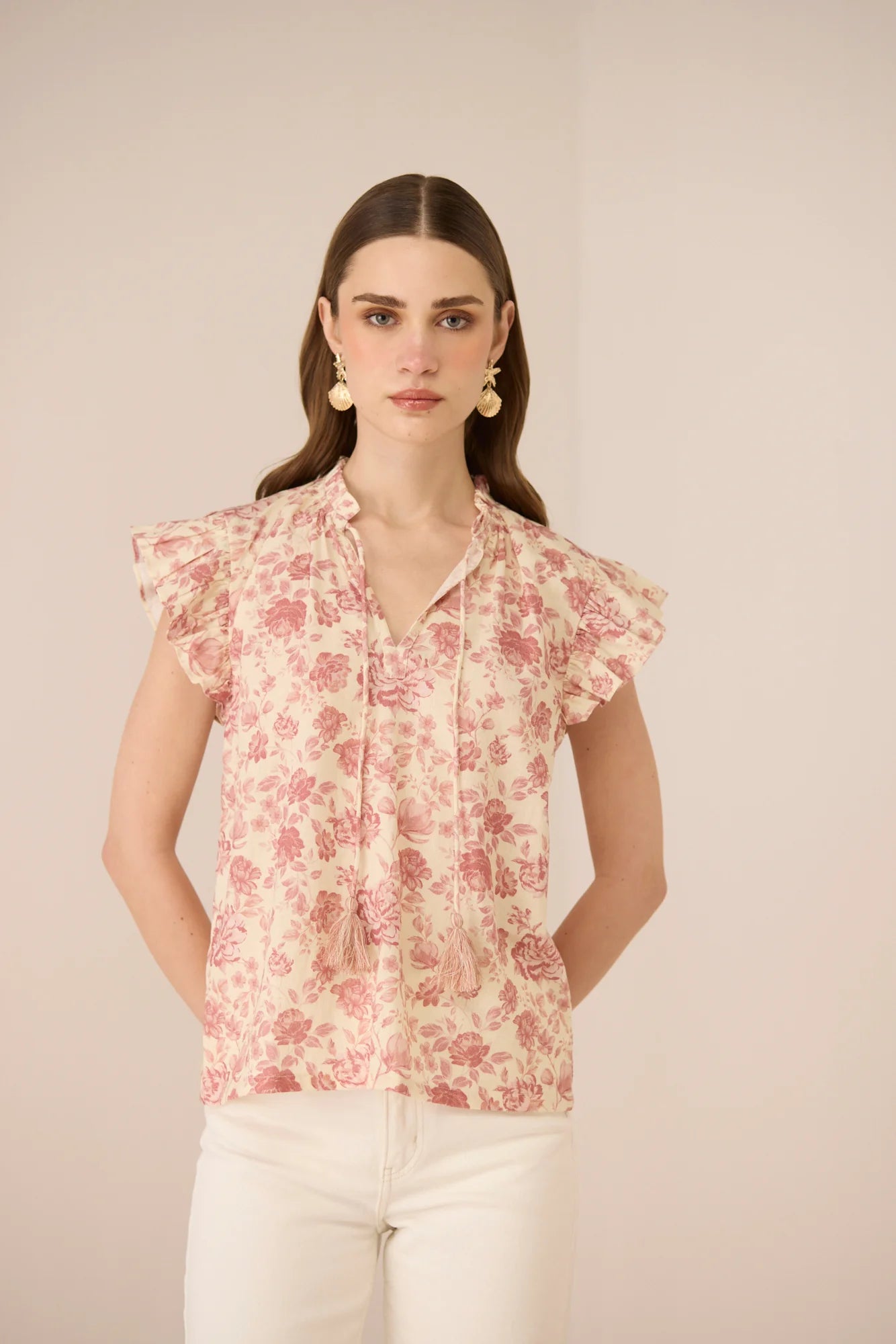 Front detail of the Madison Blouse showing the tie neckline, delicate frill sleeves, and floral print.