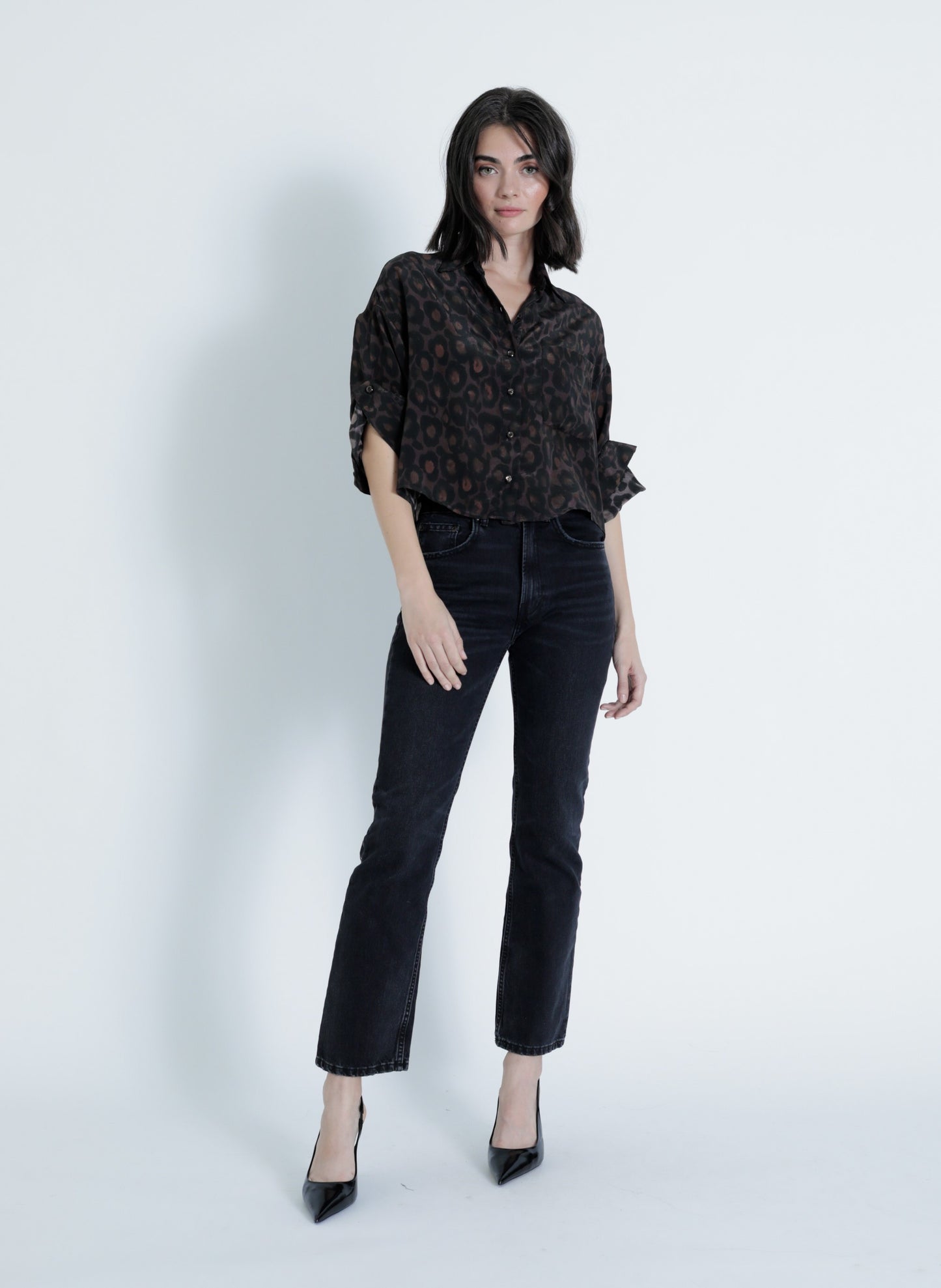 Model wearing the Malaga Print Shirt in a black leopard print viscose fabric with rolled tab sleeves and button-down front.