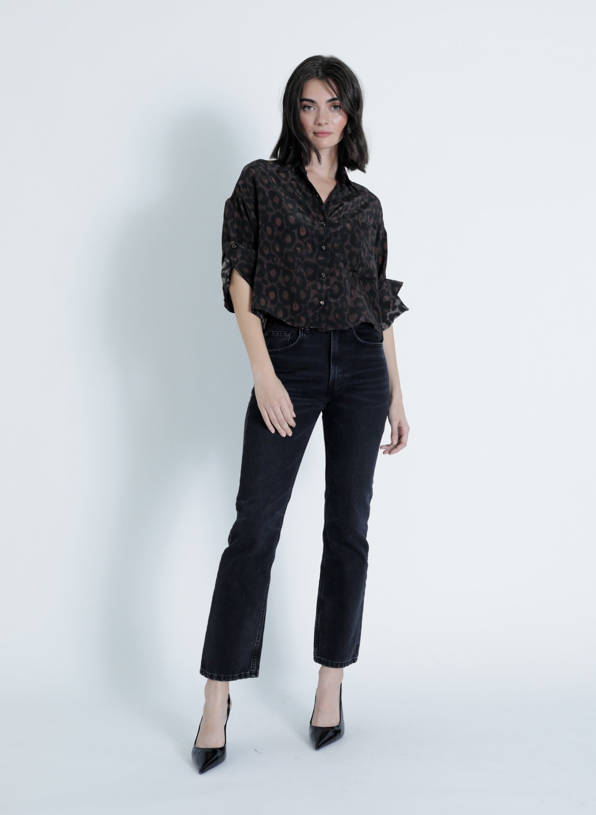 Model wearing the Malaga Print Shirt in a black leopard print viscose fabric with rolled tab sleeves and button-down front.