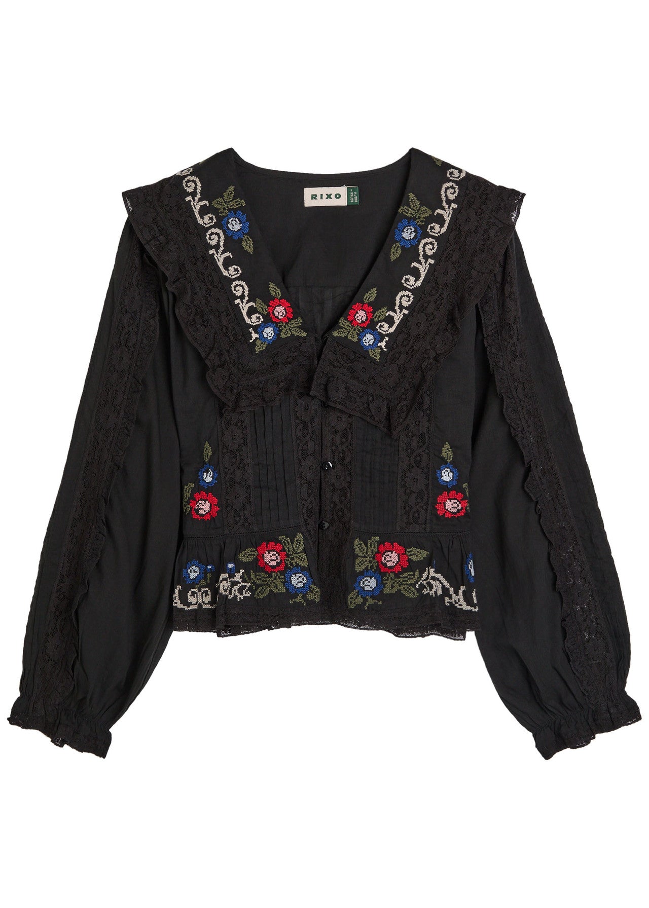 Front view of the Maribelle Top in black featuring floral cross-stitch embroidery, lace ruffle trim, and a relaxed bohemian silhouette.