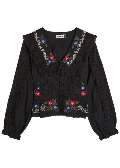 Front view of the Maribelle Top in black featuring floral cross-stitch embroidery, lace ruffle trim, and a relaxed bohemian silhouette.