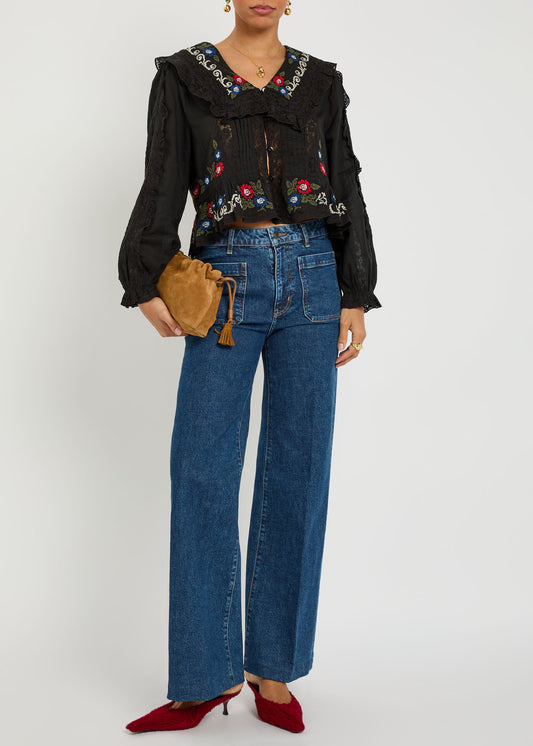 Full outfit view of the Maribelle Top styled with wide-leg denim jeans and heels, featuring colorful embroidery and romantic lace details.