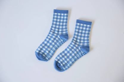 Pair of blue and white gingham Martha's Vineyard grip socks displayed flat, showcasing the checkered pattern and non-slip sole grips.