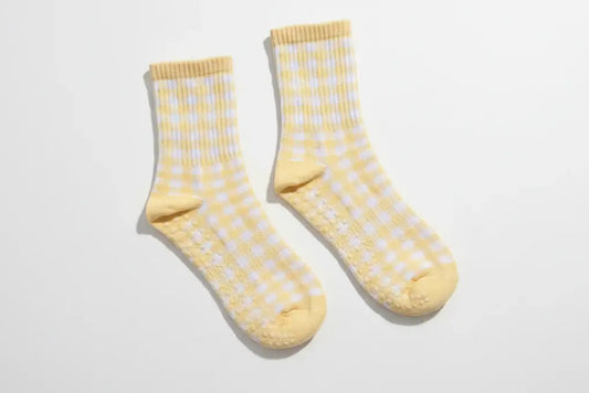 Pair of Martha's Vineyard Yellow grip socks featuring a pastel yellow and white gingham pattern, ribbed crew-length cuffs, and non-slip silicone grips designed for Pilates, Barre, yoga, and everyday wear.