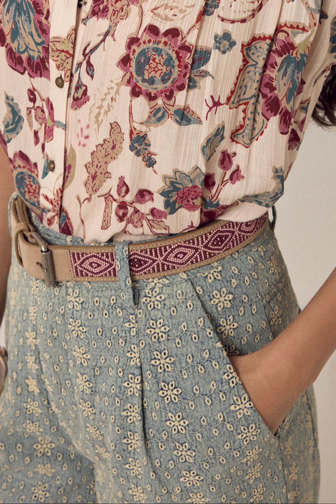 Masai Kilimanjaro beaded leather belt styled with printed blouse and patterned blue pants.