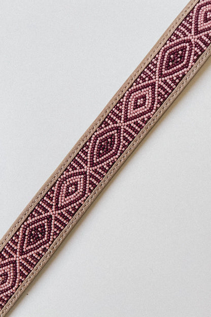 Close-up of the Masai Kilimanjaro belt with pink and burgundy geometric beadwork on leather.