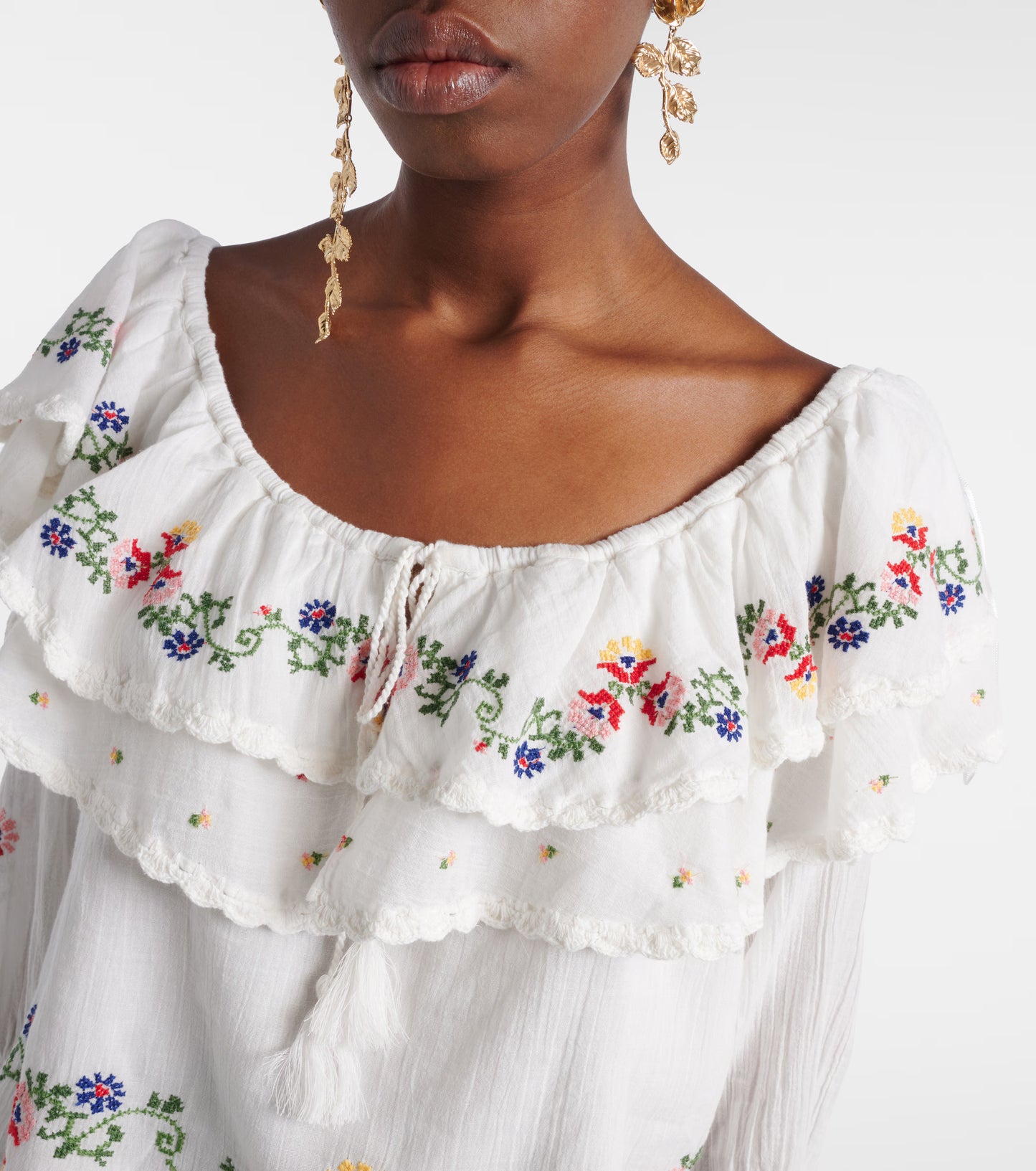 Detailed view of the Maurine top sleeve with floral embroidery and adjustable tie cuff